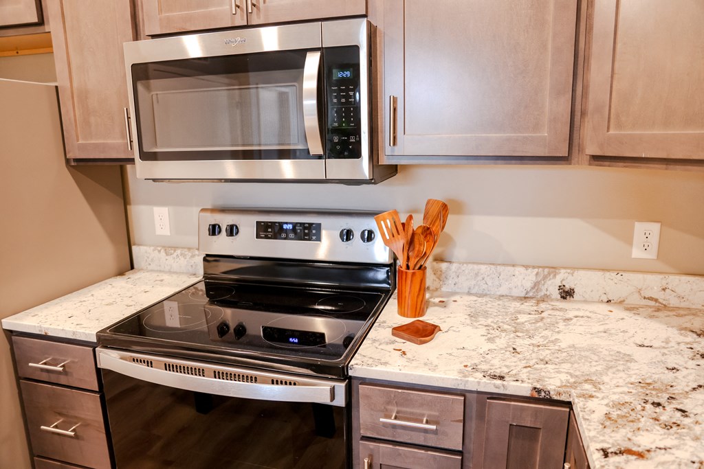 an updated kitchen with stainless steel appliances and granite counter tops
