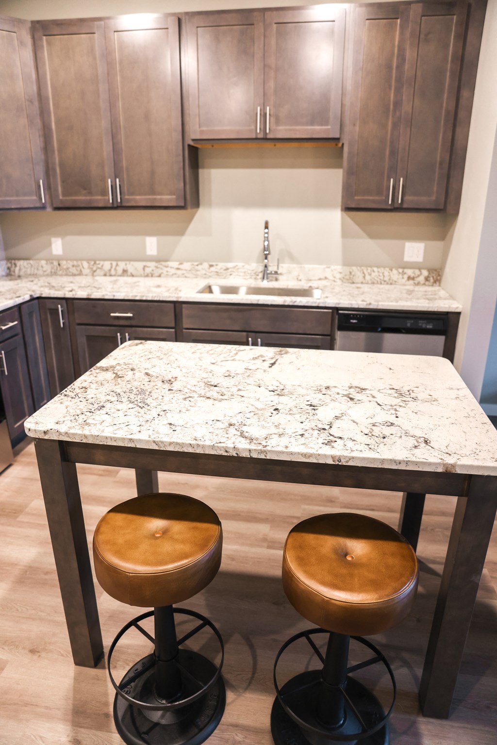 a kitchen with a marble counter top and wooden stools