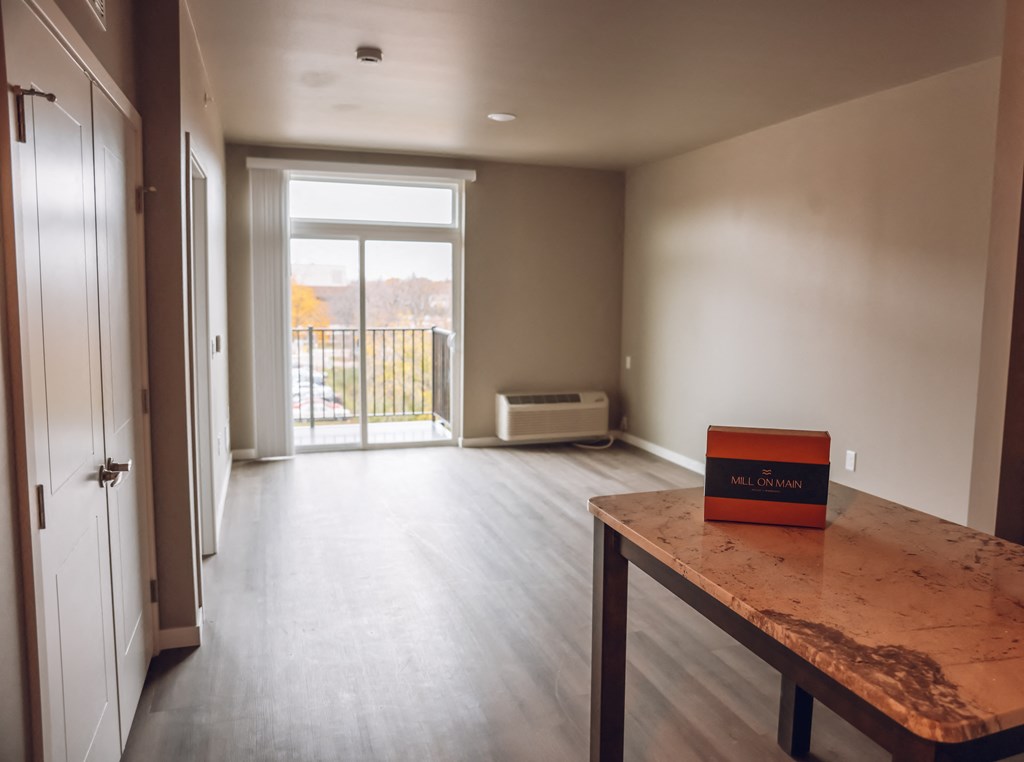 an empty living room with a wooden table with a box on it