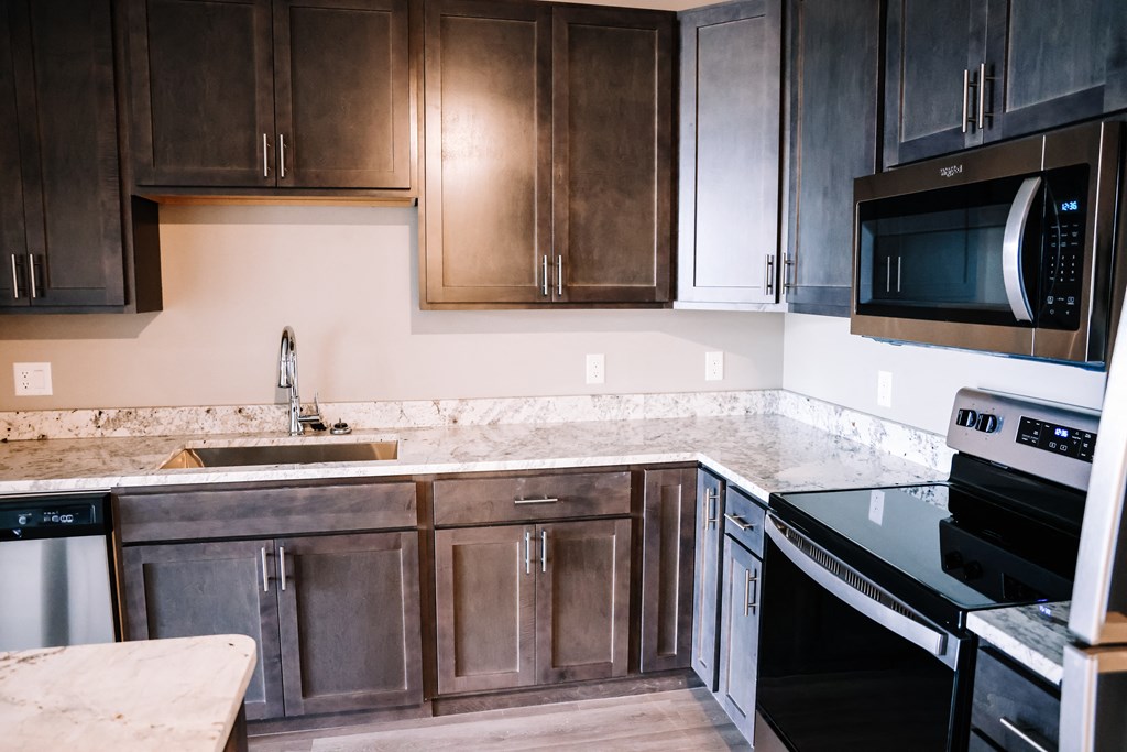 an updated kitchen with dark wood cabinets and granite counter tops