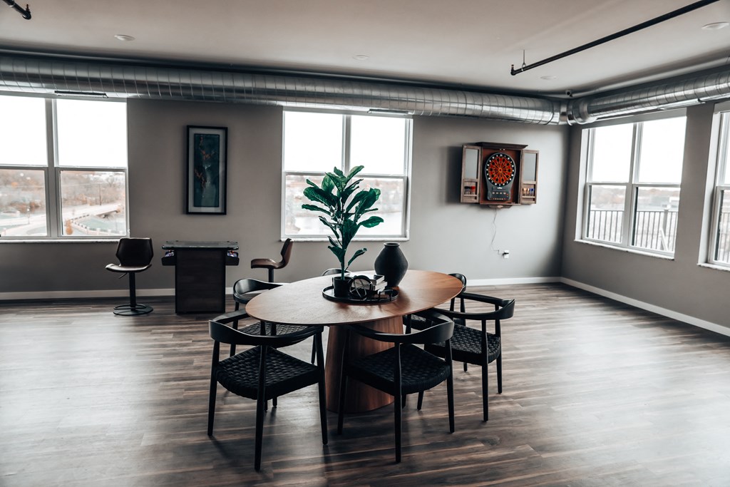 a living room with a wooden floor and a table and chairs