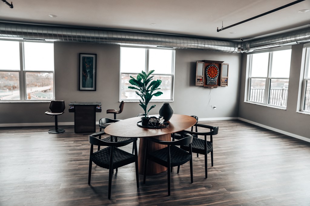 a living room with a wooden floor and a table and chairs