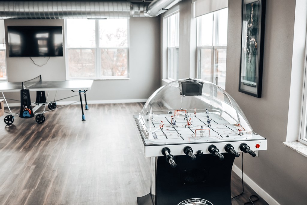 a game room with a foosball table and a tv