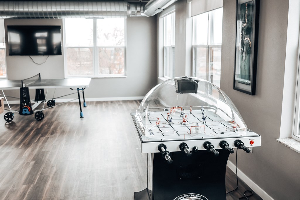 a game room with a foosball table and a tv