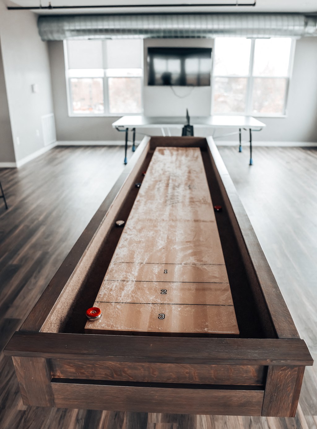 a shuffleboard table in a room with wood floors