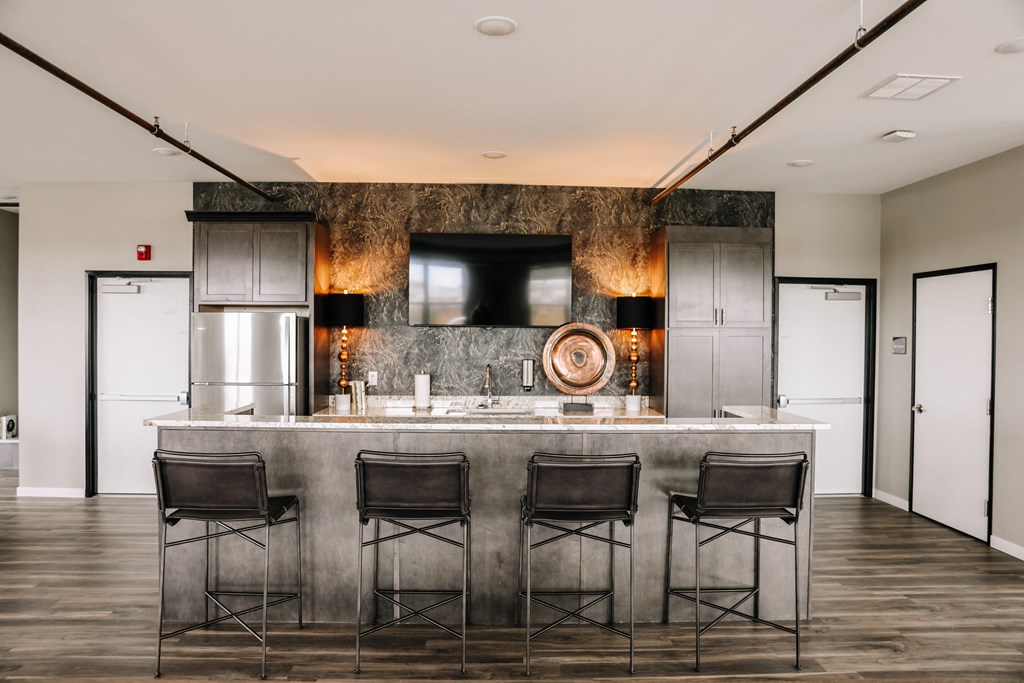 a kitchen with a marble counter top and three stools