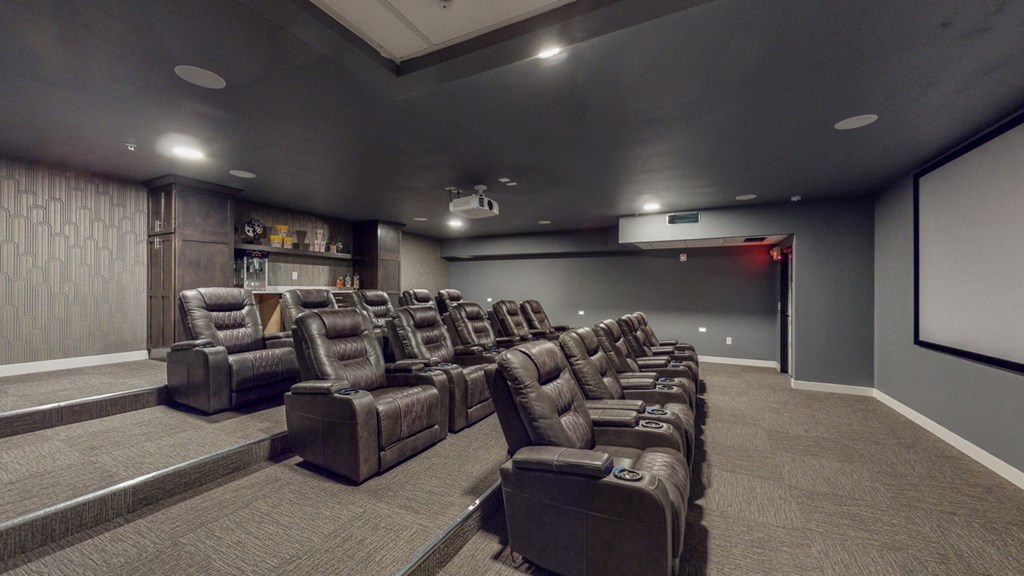 a large screening room filled with leather seats and a projector screen