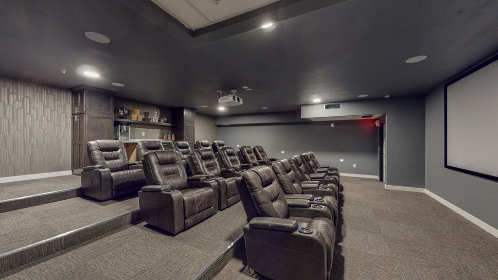 a large screening room with leather chairs and a projector screen