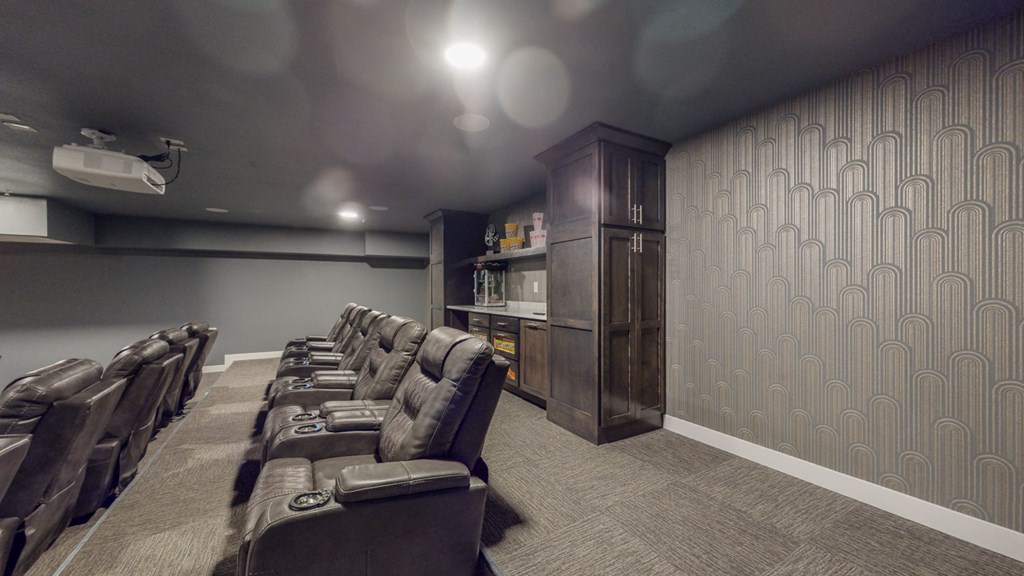 a small screening room with leather seats and a wooden cabinet