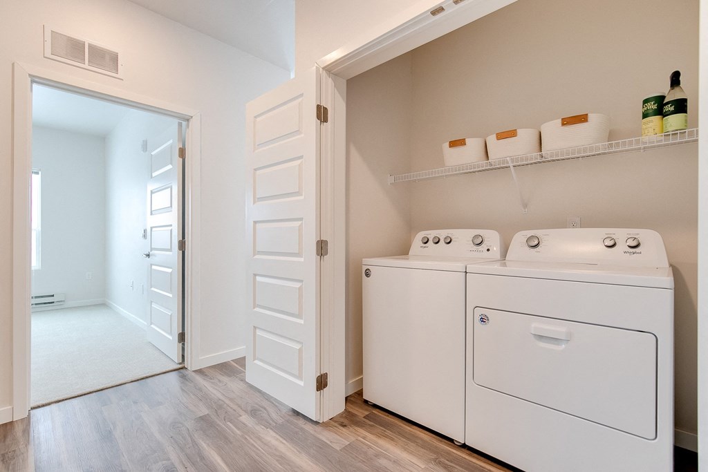 a spacious laundry room with a washer and dryer and a door to a
