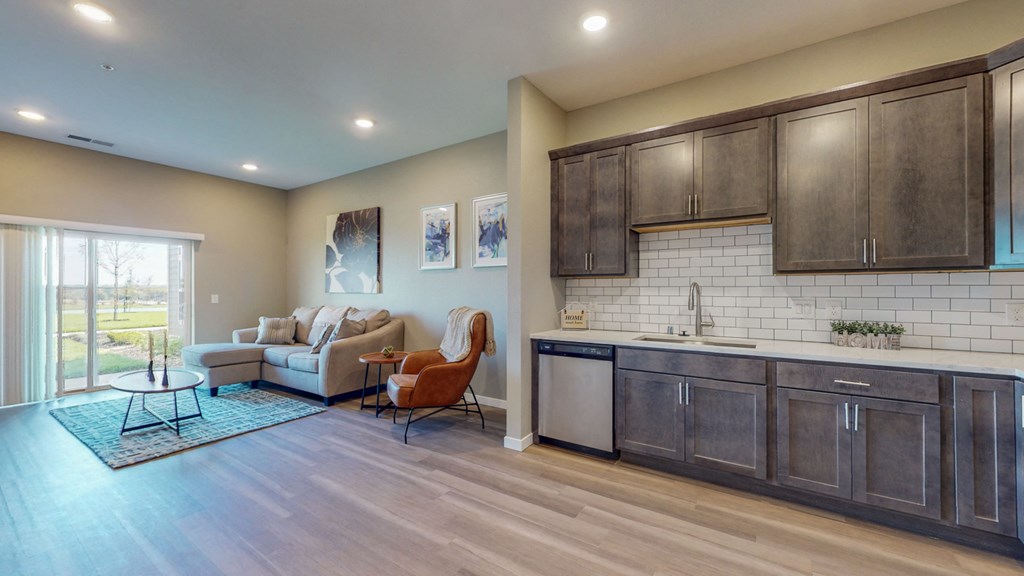 a living room with a couch and a kitchen with a sink
