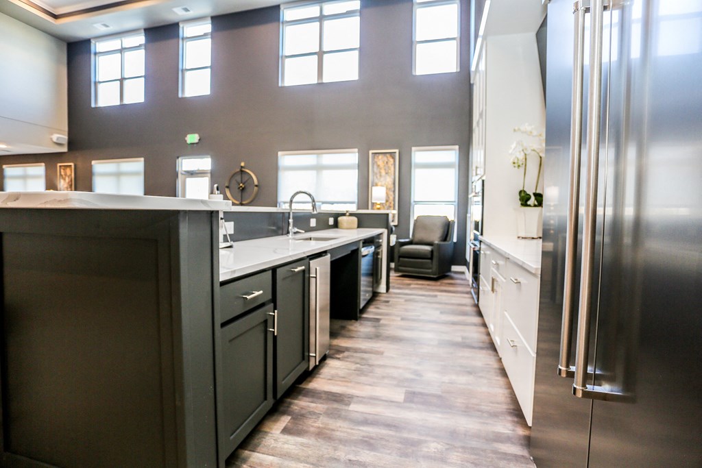 a large kitchen with stainless steel appliances and a long hallway to the living room