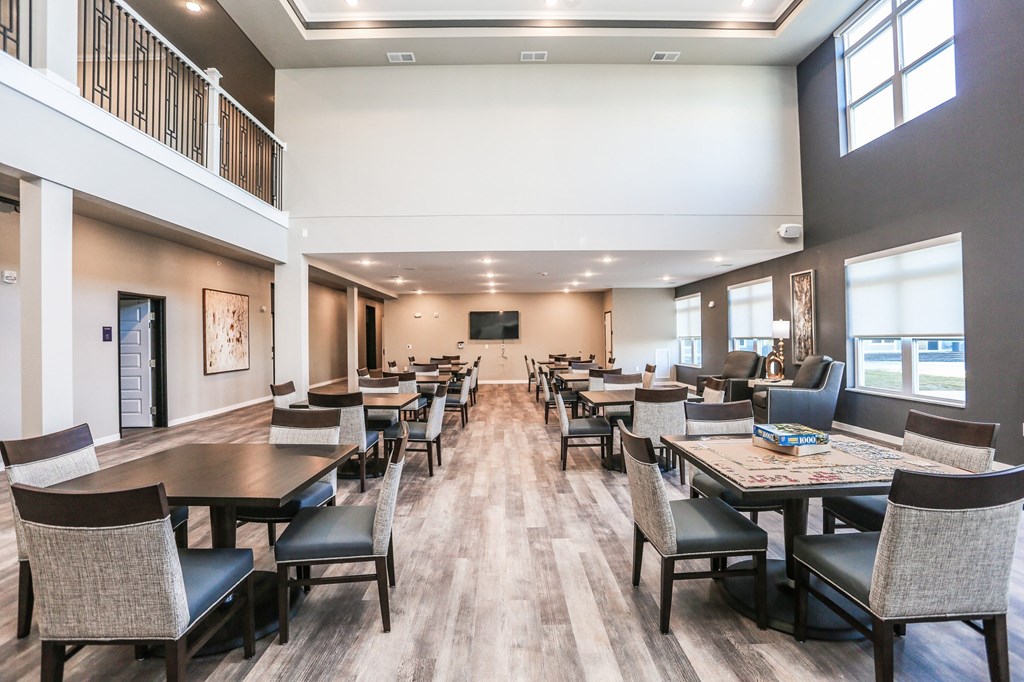 a large dining room with tables and chairs and a balcony