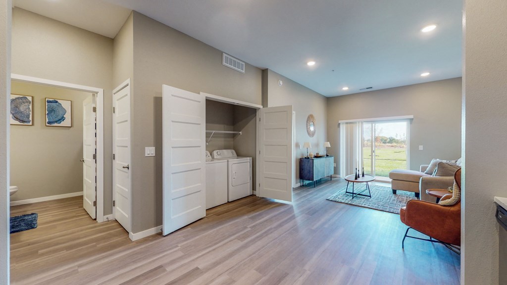 an open living room and bedroom with an open closet and a couch
