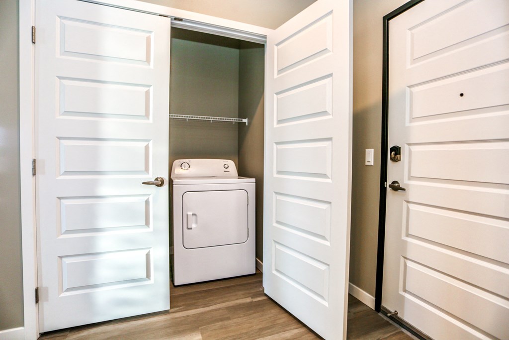 a white washer and dryer in a room with white doors