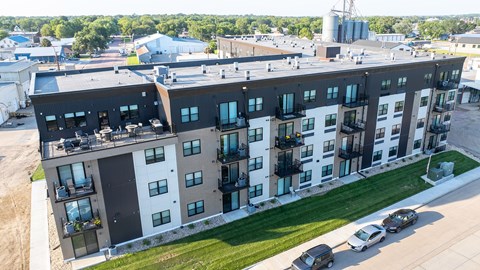 A modern apartment building with a parking lot in front.
