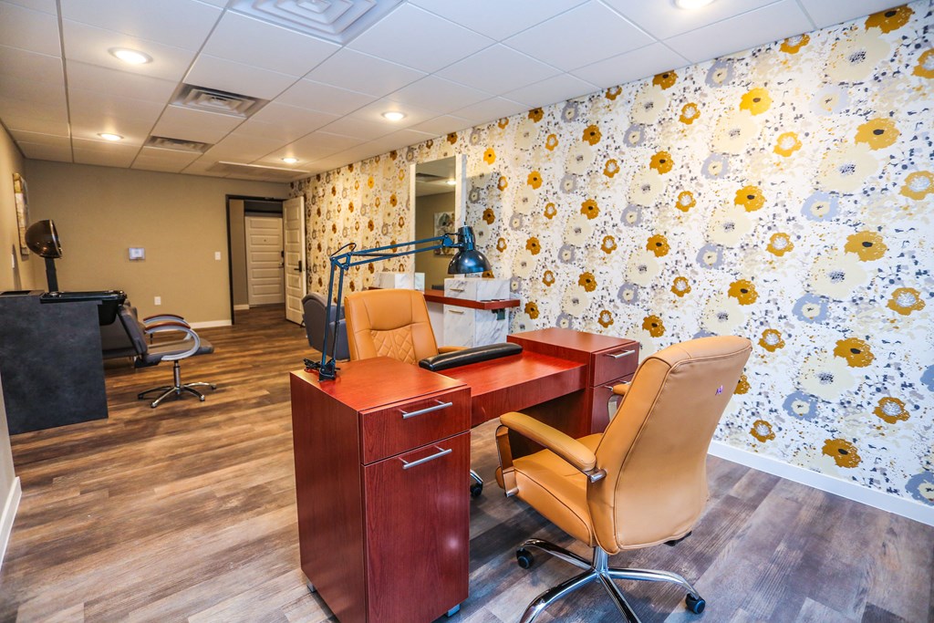 a business center with a desk and chair and a flower wallpaper