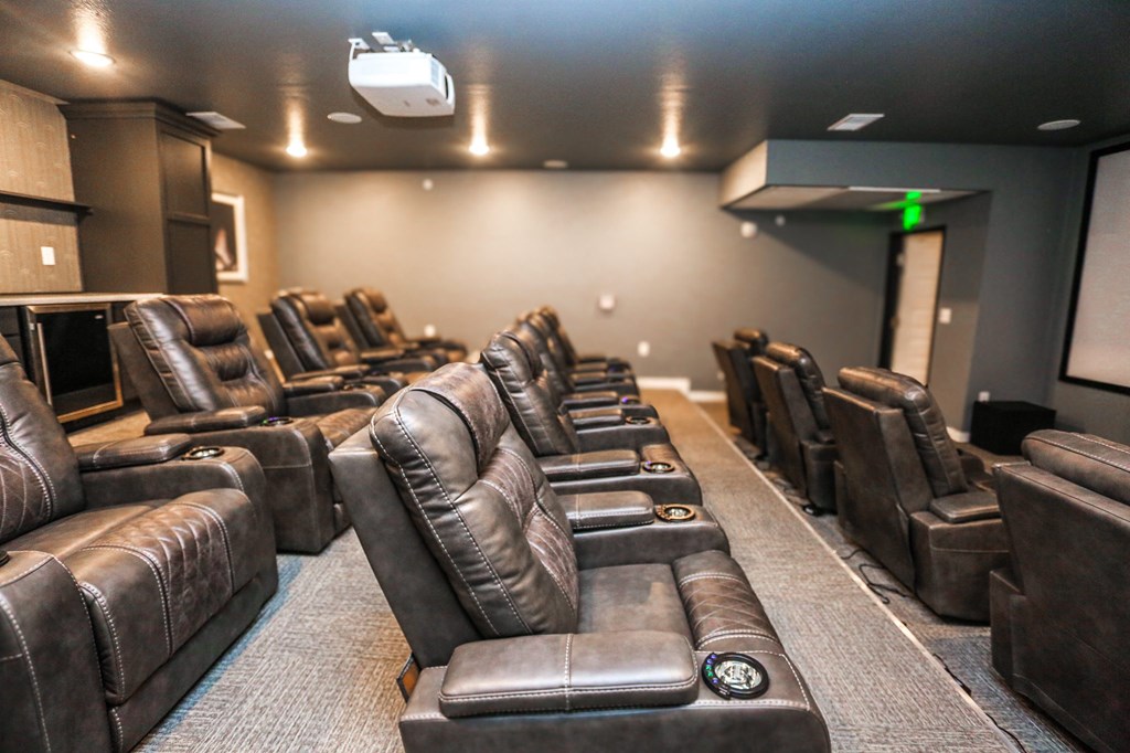 a large screening room with leather chairs and a projector