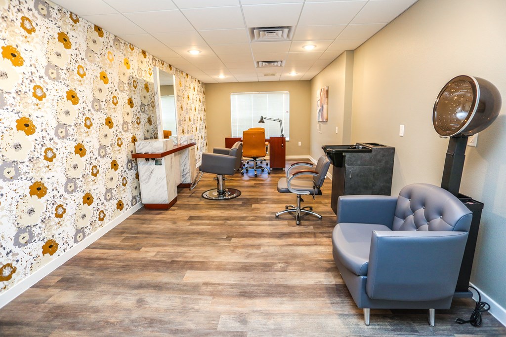 a salon room with blue chairs and a hair salon counter