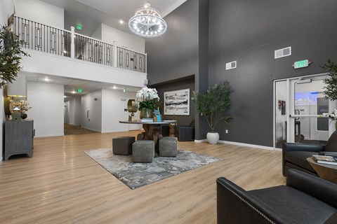 A spacious living room with a black couch and a chandelier.