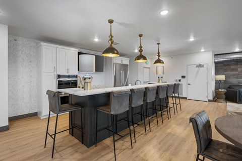 A kitchen with a long table and chairs.