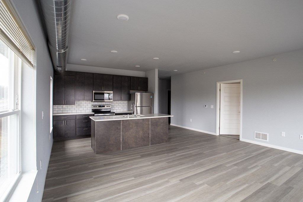 a large kitchen with stainless steel appliances and a large window