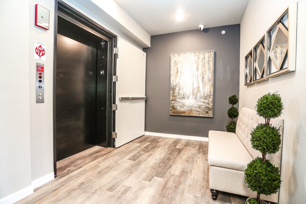 a hallway with a black door and a couch and a painting