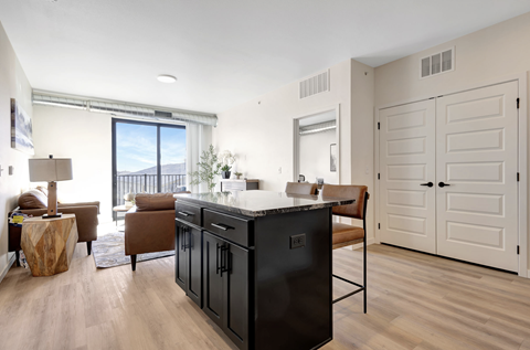 A kitchen with black cabinets and a wooden island.