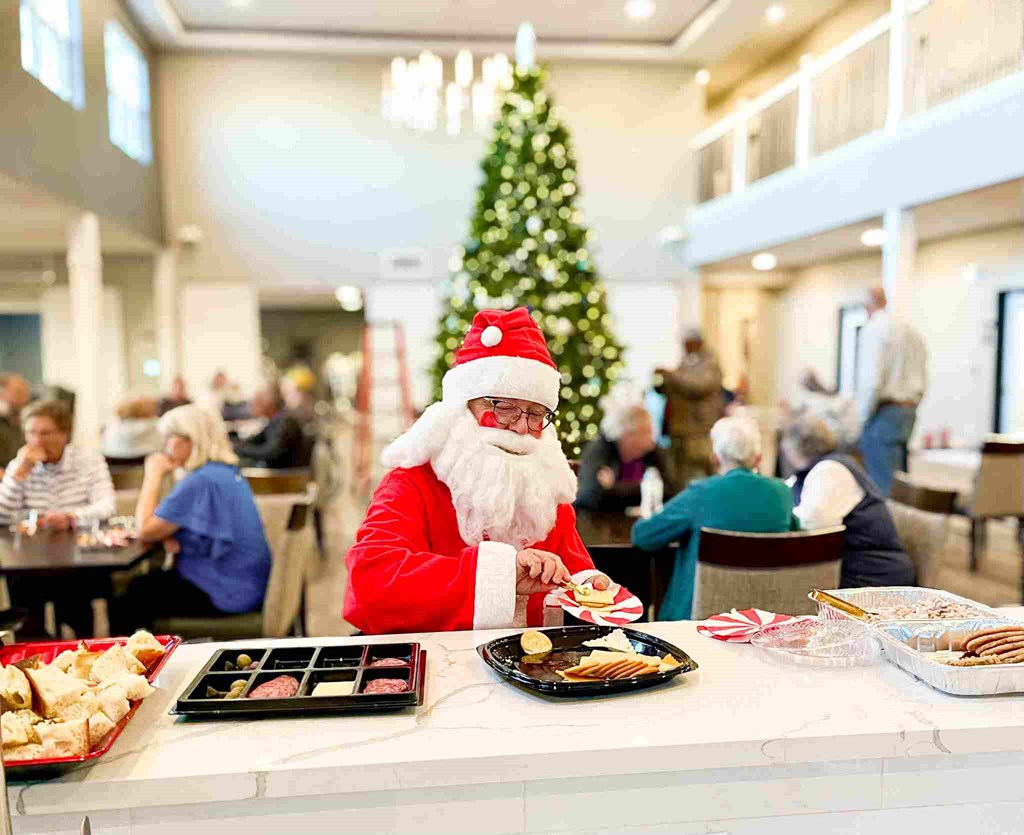 a man in a santa claus costume sitting at a table with food