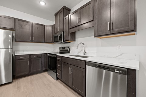 A modern kitchen with dark wood cabinets and stainless steel appliances.