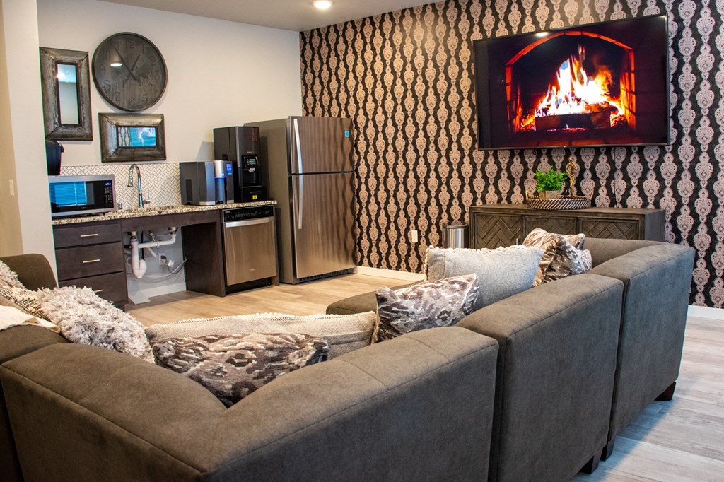 a living room with a fireplace and a kitchen
