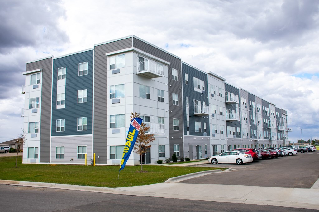 a new apartment building with cars parked in front of it