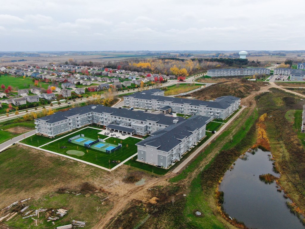 an aerial view of a campus with buildings and a body of water