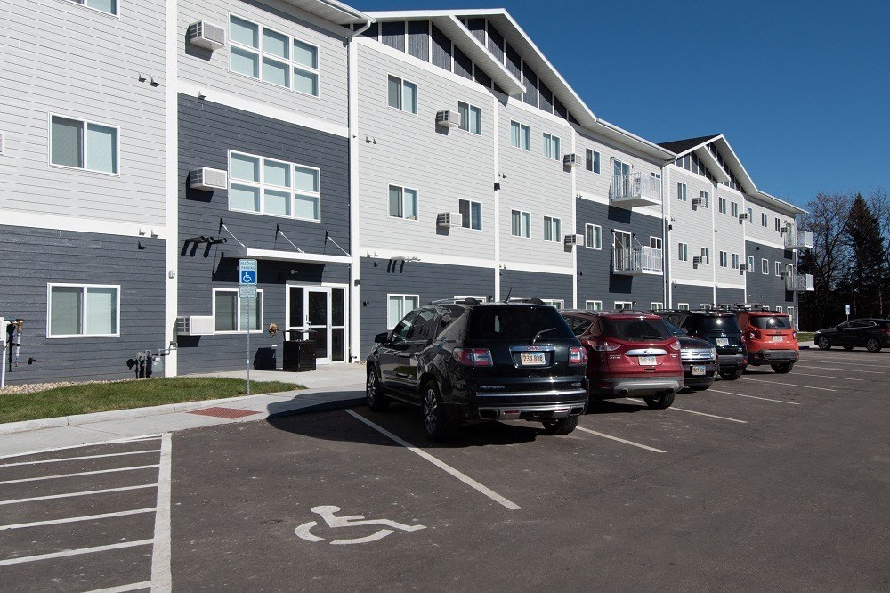 a parking lot with cars in front of a building
