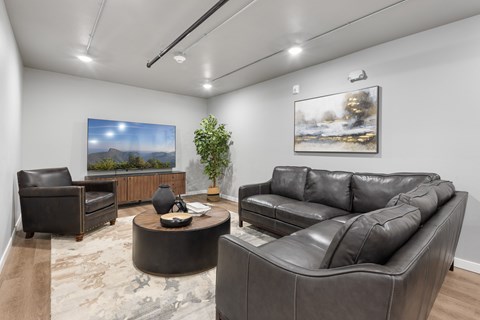 A living room with a couch, chair, and a painting on the wall.