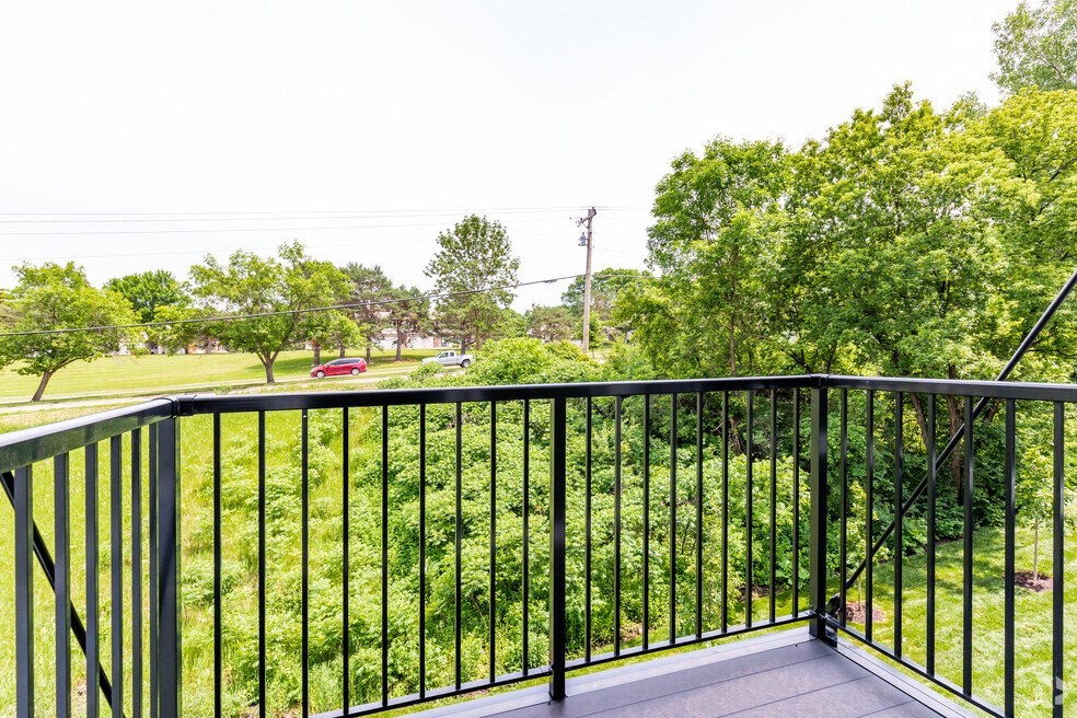a balcony with a view of a yard and trees