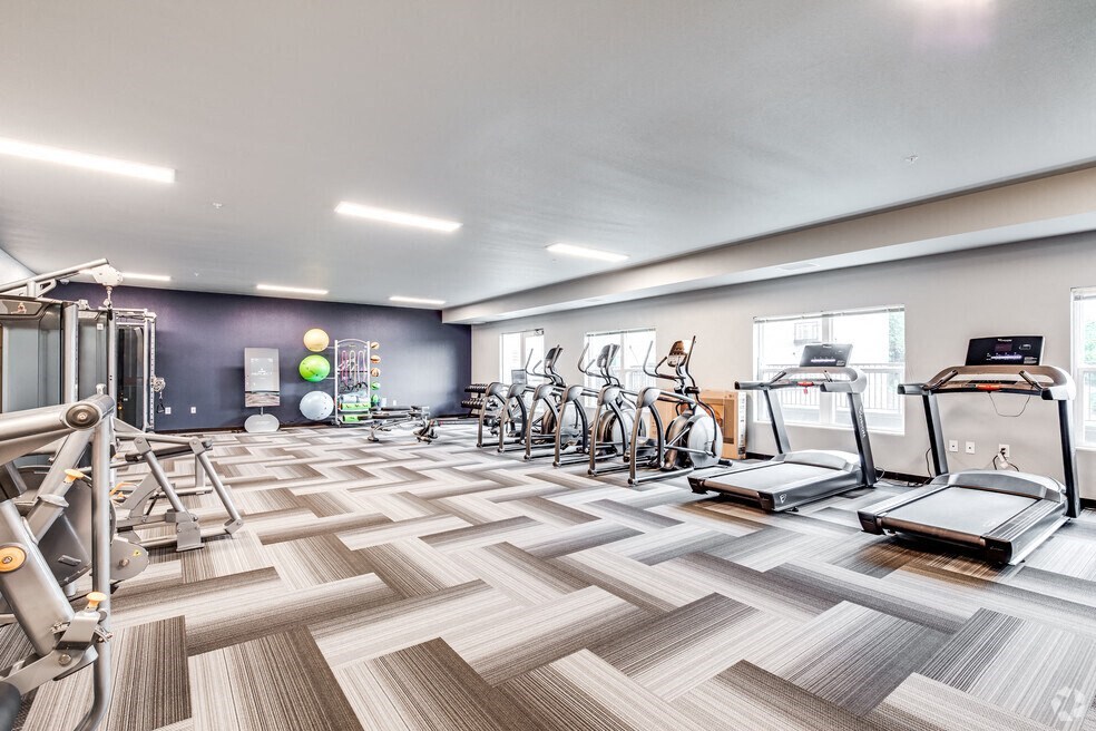 a gym with cardio machines and weights on a checkered floor