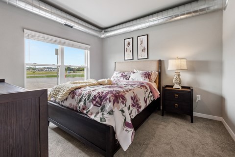 a bedroom with a bed and a large window