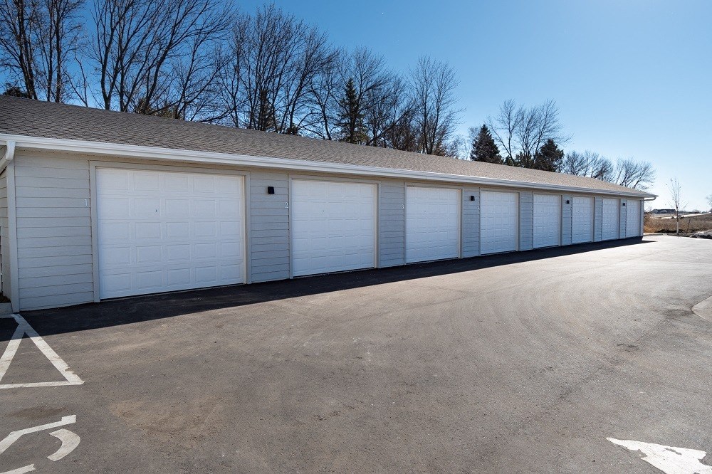 a row of white garage doors on the side of a building