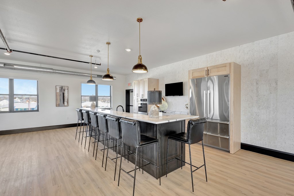 A kitchen with a long table and chairs.