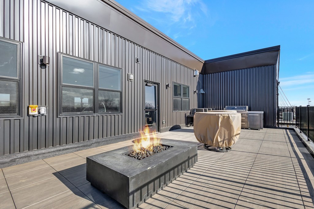 A modern building with a fire pit on the patio.