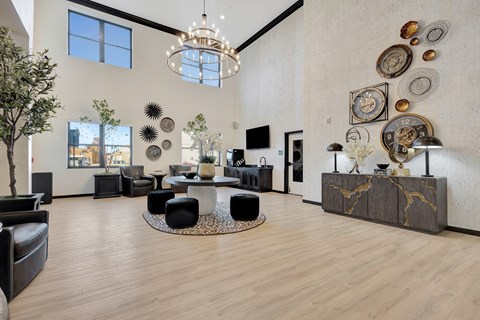 A modern living room with a large circular table and a chandelier.