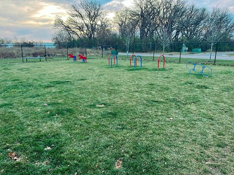 A playground with red, blue, and green swings.