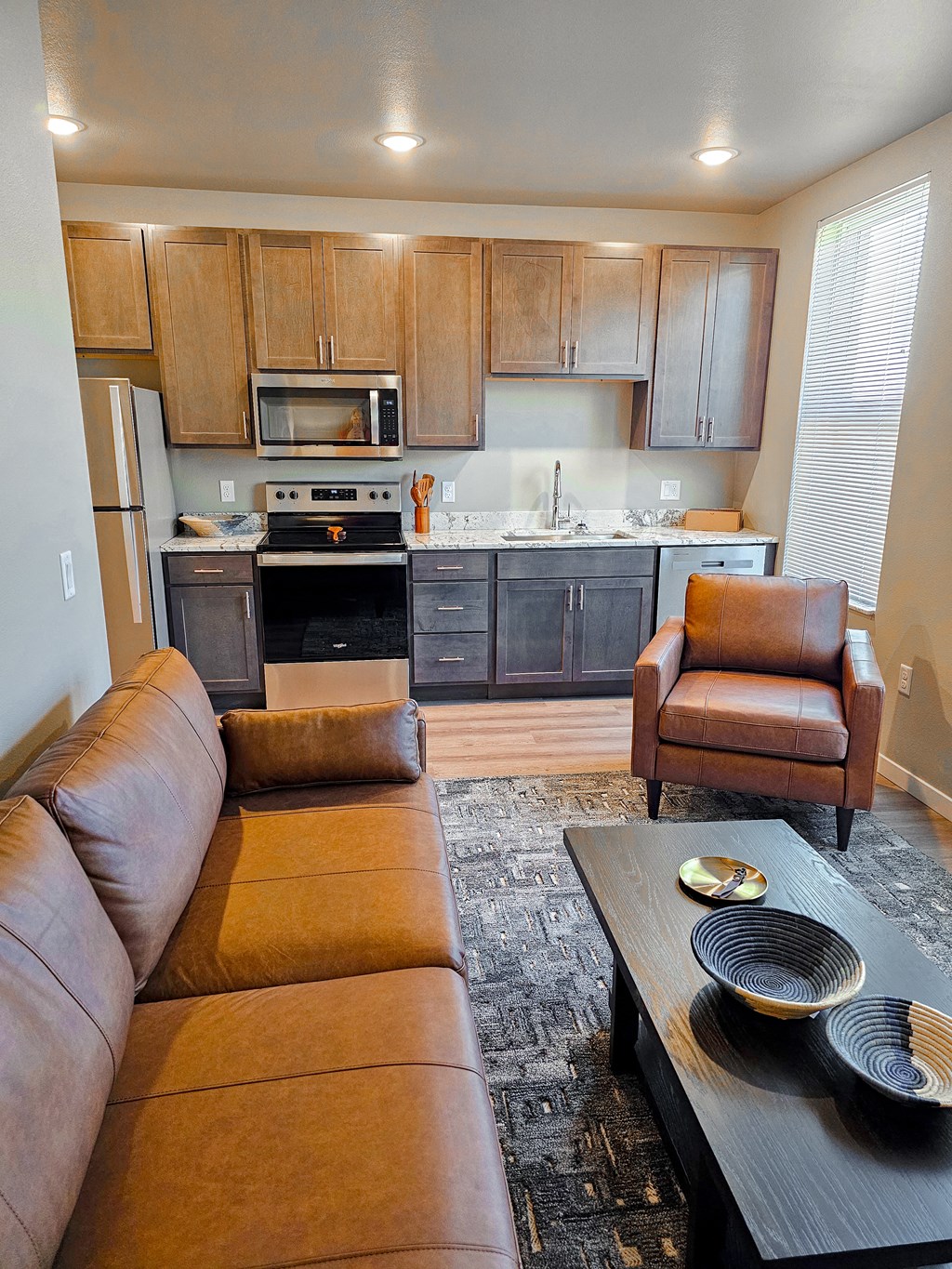 a living room with a couch in front of a kitchen