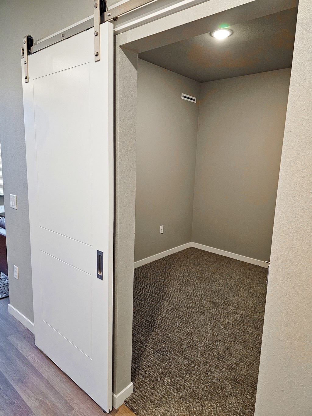 a bedroom with a white door and a carpeted floor