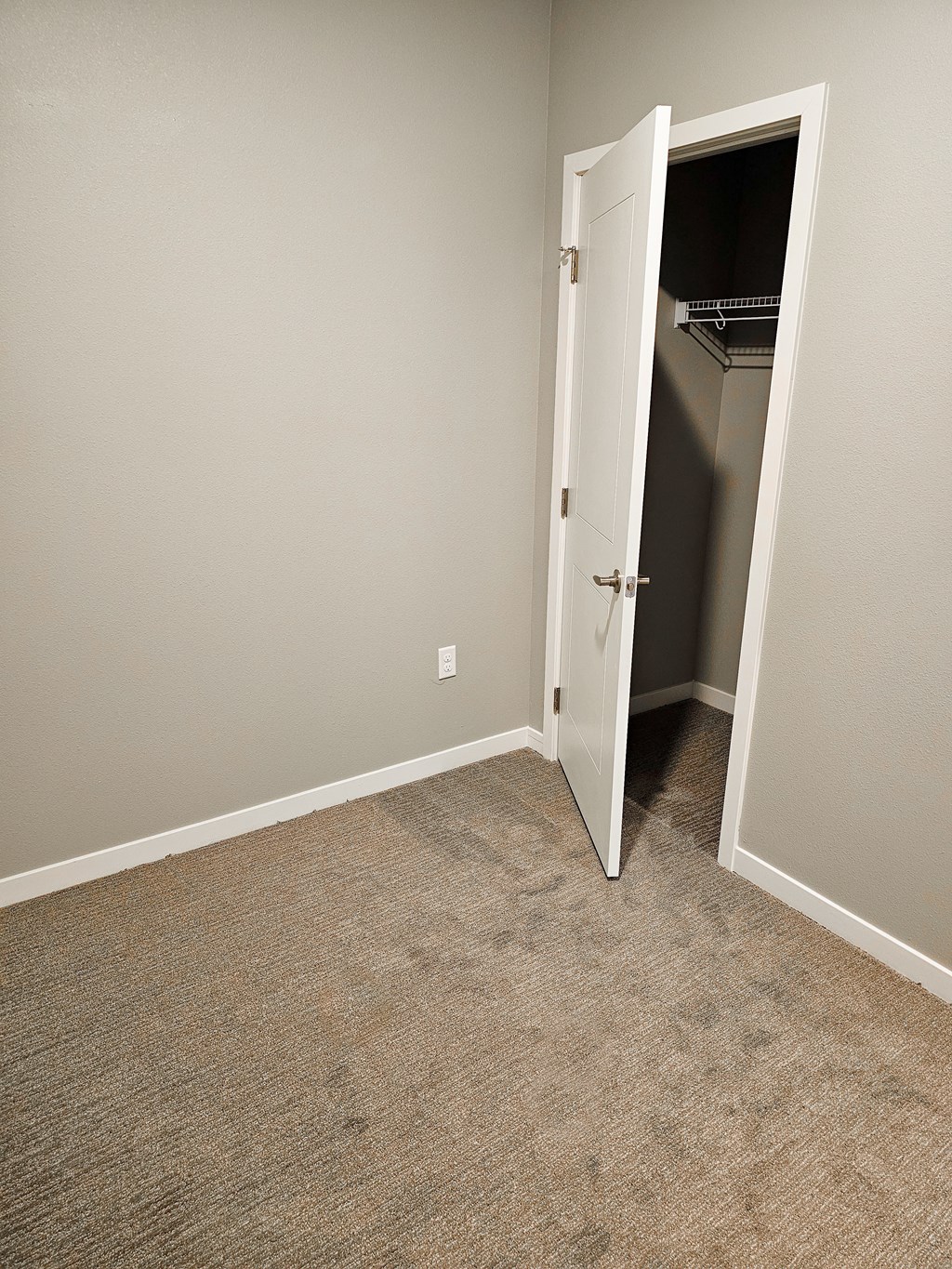 an empty room with a closet and an open door