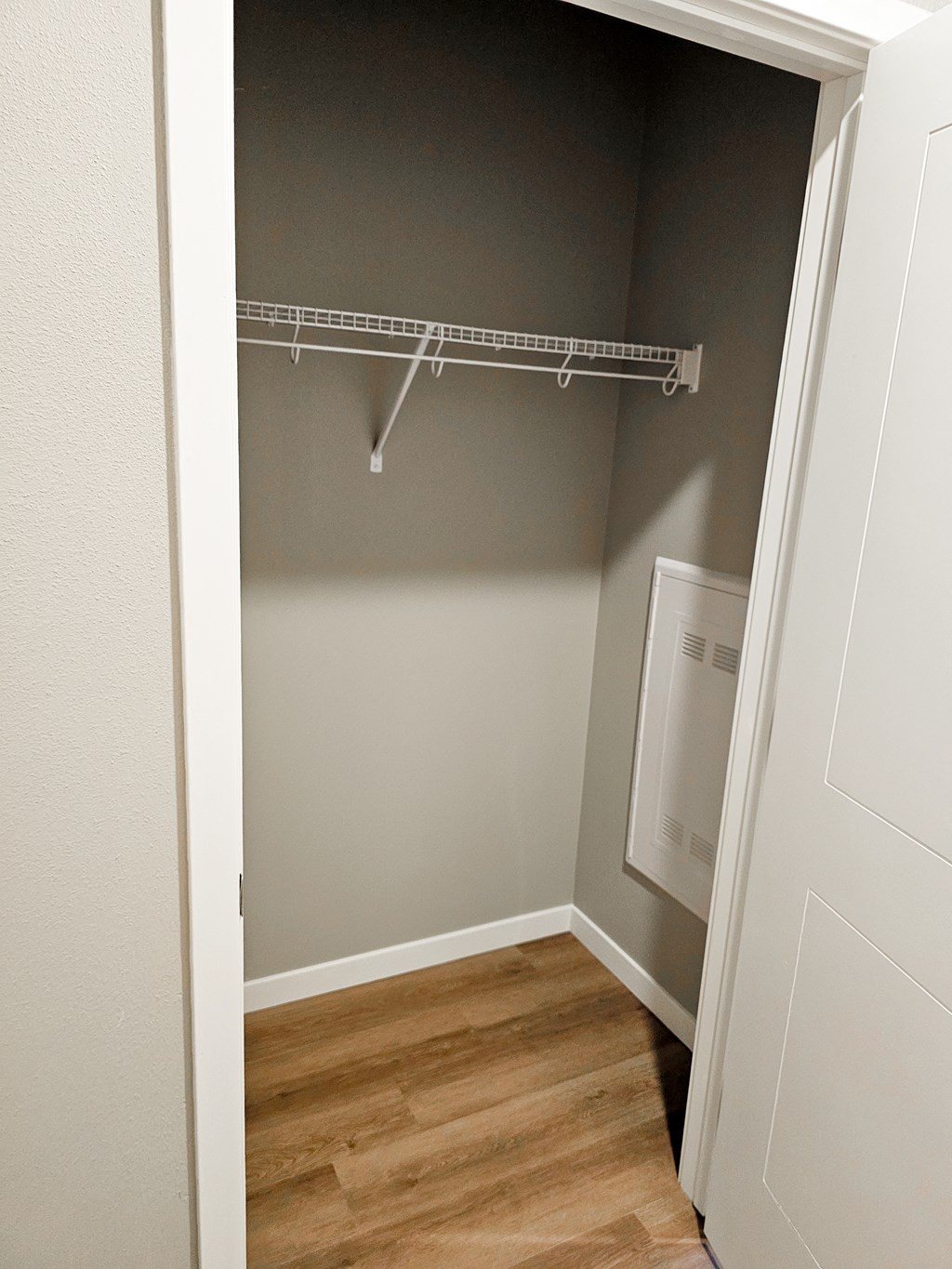 a bedroom with a closet and a mirrored closet with a clothes rack