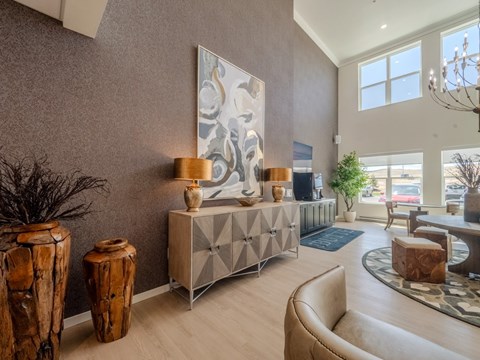 A living room with a large abstract painting on the wall, a wooden side table, and a beige sofa.