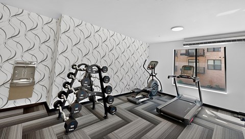 fitness room with weights and treadmill