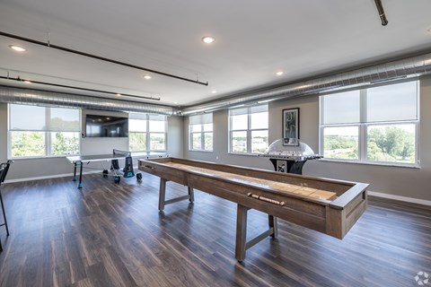 A room with a pool table and a television.